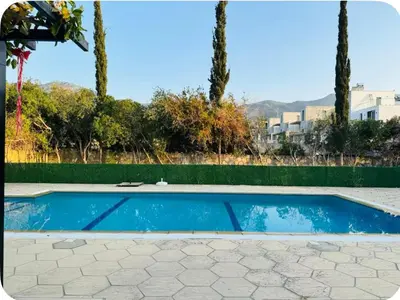 a swimming pool in a yard with palm trees at A Spacious Villa to Entertain in Aglantzia