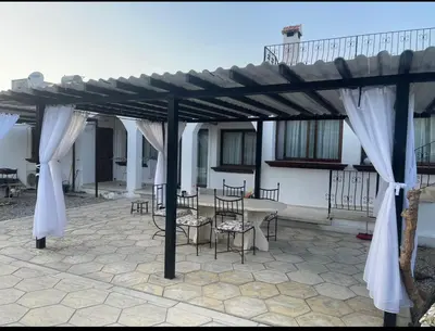 a wooden pergola with a table and chairs under it at A Spacious Villa to Entertain in Aglantzia