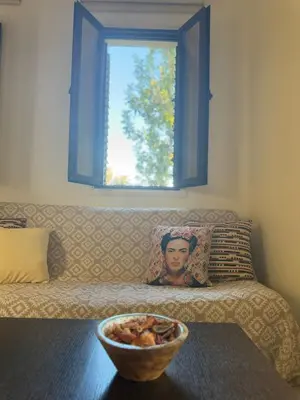 a bowl of fruit on a table in front of a couch at Tranquil Poolside apartment with stunning views in Mazotos