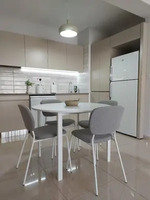 a kitchen with a table and chairs and a refrigerator at Bird's Nest, close to EMU, in the city center in Dherinia
