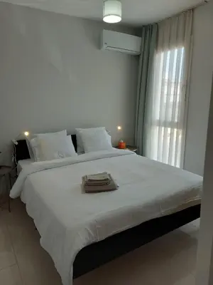 a bedroom with a large white bed with towels on it at Bird's Nest, close to EMU, in the city center in Dherinia