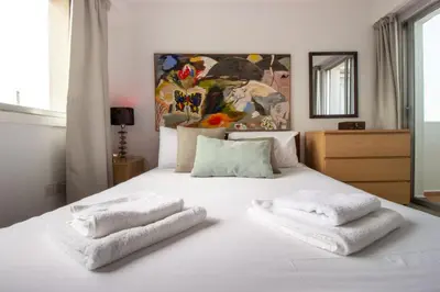 a bedroom with a white bed with towels on it at Central 1BR - Views - Deli Café in Nicosia