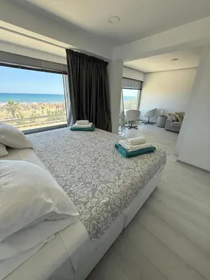a bedroom with a large bed with a large window at Marimar2 paradise by the Sea in Larnaka