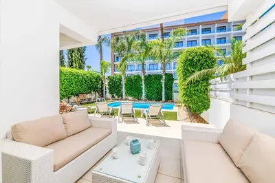 a patio with white furniture and a swimming pool at Villa Atlantis in Protaras
