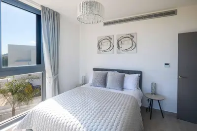 a bedroom with a white bed and a large window at Villa Almaria ALM28 in Protaras