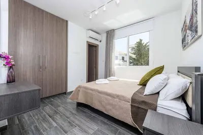 a bedroom with a large bed and a window at Green Bay Villa 15 in Protaras