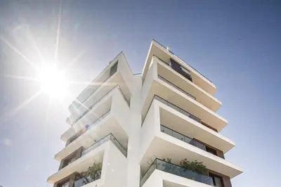 a building with the sun in the background at CasaMar - Upscale One-Bedroom Apartment by the Sea in Larnaka