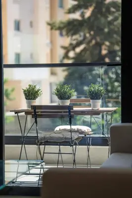 a table with three potted plants on it in front of a window at CasaMar - Upscale One-Bedroom Apartment by the Sea in Larnaka