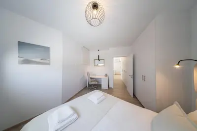 a white bedroom with a bed and a desk at CasaMar - Upscale One-Bedroom Apartment by the Sea in Larnaka