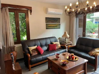 a living room with a leather couch and a table at Αετοφωλιά-AETOFOLIA in Pano Lefkara