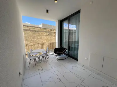 a room with a table and chairs on a balcony at SWIFT Suites Limassol in Limassol