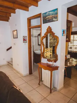 a living room with a mirror and a table at Revecca House in Ayios Mamas