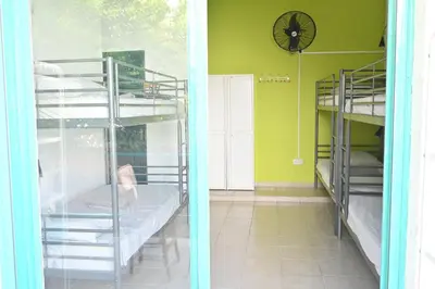 two bunk beds in a room with a clock on the wall at Lemongrass Hostel in Limassol