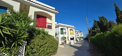 a white building with a red window on a street at Barefoot Beach House in Larnaka