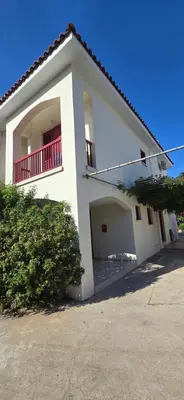 a white house with a balcony and a garage at Barefoot Beach House in Larnaka