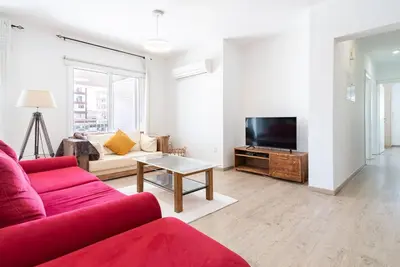 a living room with a red couch and a tv at Sunny & Stylish City Centre Living in Nicosia