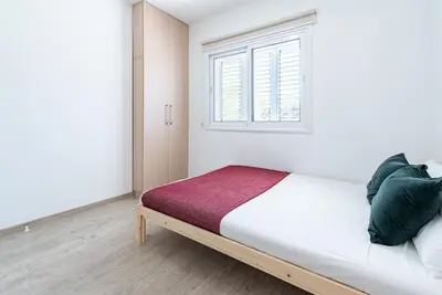 a white bedroom with a bed with a window at Sunny & Stylish City Centre Living in Nicosia