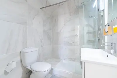 a bathroom with a toilet and a shower and a sink at Sunny & Stylish City Centre Living in Nicosia