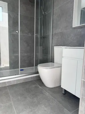 a bathroom with a toilet and a glass shower at Costas court in Limassol