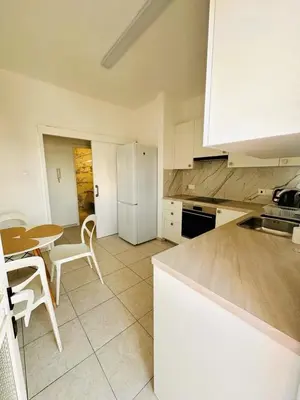 a kitchen with a table and a white refrigerator at Charming 2 Bdr Nicosia Apt Free Parking & Wi-Fi in Nicosia