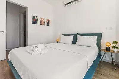 a white bedroom with a large white bed and a table at Azure Sama Villa in Protaras