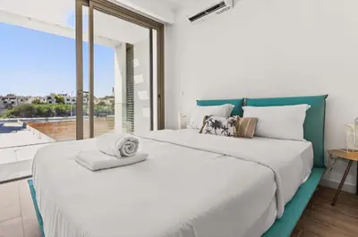 two beds in a bedroom with a large window at Azure Leda Villa in Protaras