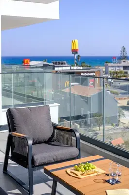a chair and a table with a plate of fruit on a balcony at Artemis 302 - Seaside Stories in Livadhia