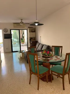 a living room with a dining room table and chairs at Two Floor Maisonette by the Sea in Protaras