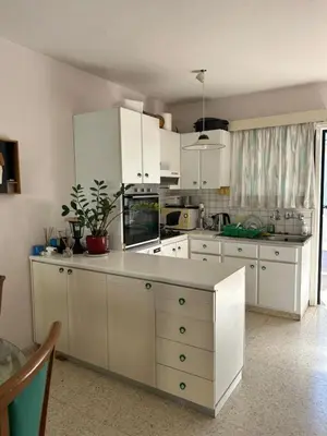 a kitchen with white cabinets and a white counter top at Two Floor Maisonette by the Sea in Protaras