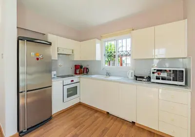 a kitchen with white cabinets and a stainless steel refrigerator at Anemone Seaview Villa DPS01 in Protaras