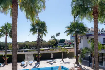 a view of a resort with palm trees and a pool at Amethyst Napa Annex Apartments in Ayia Napa