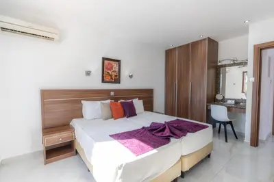 a bedroom with a large bed and a desk at Amethyst Napa Annex Apartments in Ayia Napa