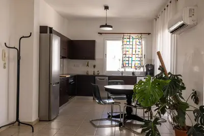 a kitchen with a table and a refrigerator at Penthouse, City Center, Walking to Beach in Larnaka
