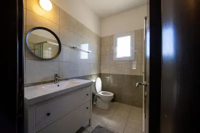 a bathroom with a sink and a mirror and a toilet at Penthouse, City Center, Walking to Beach in Larnaka