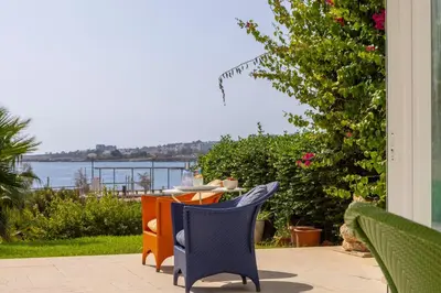 a blue chair sitting on a patio with a view of the water at Protaras Seafront Villa AleMar in Protaras