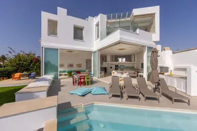 a villa with a swimming pool and a house at Protaras Seafront Villa AleMar in Protaras