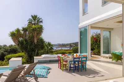 a patio with a table and chairs and a pool at Protaras Seafront Villa AleMar in Protaras