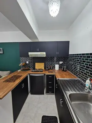 a kitchen with black cabinets and a sink at D&D Apartment in Paralimni