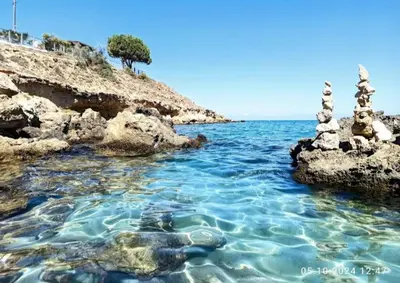 two towers in the water next to a rocky shore at D&D Apartment in Paralimni