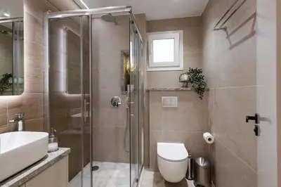 a bathroom with a shower and a toilet and a sink at Luxury Marina Beach Stay in Limassol