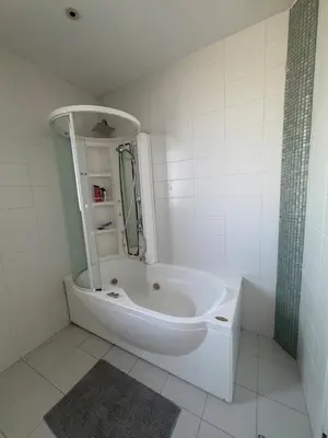 a white bathroom with a tub and a mirror at Stunning Penthouse with Sea and City View in Larnaka