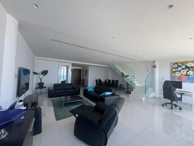 a large living room with couches and a piano at Stunning Penthouse with Sea and City View in Larnaka