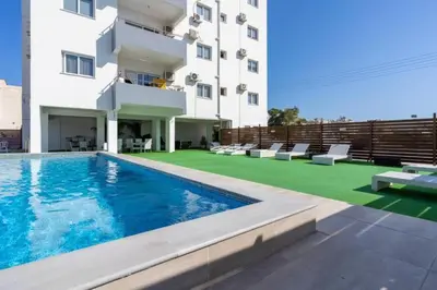 a hotel with a swimming pool and a building at Phoenix 2-Bedroom Apartment in Larnaka