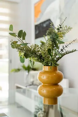 a vase filled with plants on a glass table at 1 bedroom flat next to university in Aglantzia