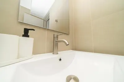 a bathroom sink with a faucet and a mirror at 1 bedroom flat next to university in Aglantzia