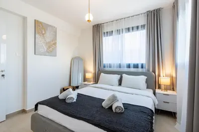 a bedroom with a large bed with towels on it at Jas Living - Chic Apts & Balconies in Larnaca in Larnaka