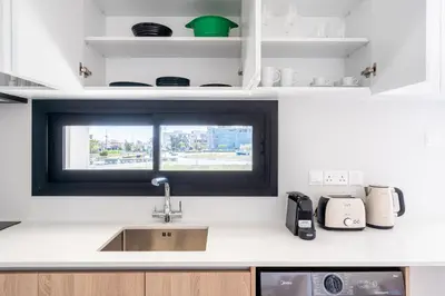 a kitchen counter with a sink and a window at Jas Living - Chic Apts & Balconies in Larnaca in Larnaka