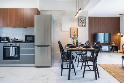 a kitchen with a table with chairs and a refrigerator at Vervana 2-Bedroom Apartment in Larnaka