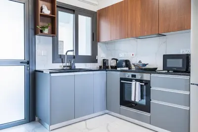 a kitchen with stainless steel appliances and wooden cabinets at Vervana 2-Bedroom Apartment in Larnaka