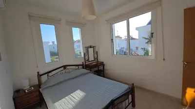 a bedroom with a bed in a room with windows at Chrystallia Protaras in Paralimni